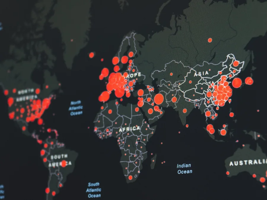 Carte du monde sombre parsemée de cercles rouges de tailles variées, image d'une cartographie des menaces